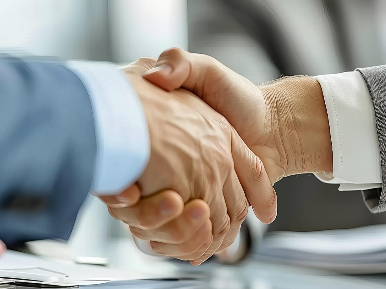 Zwei Hände werden geschüttelt. Hier können Sie Workshops und Keynotes buchen.